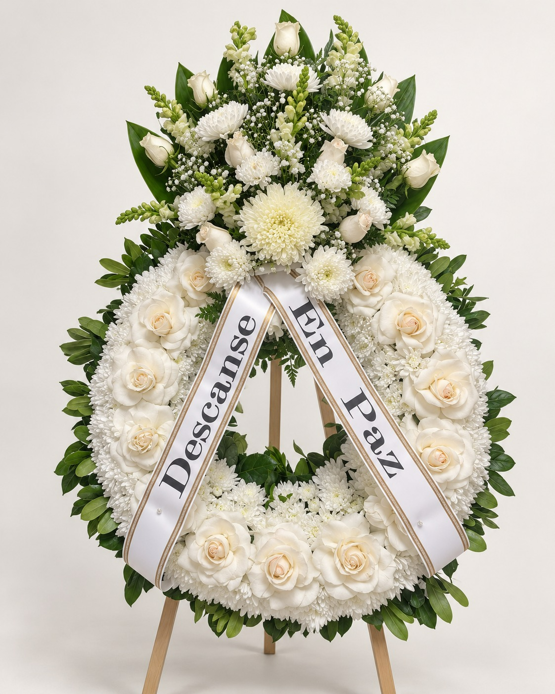 Corona floral fúnebre blanca con listones «Descanse En Paz» sobre atril